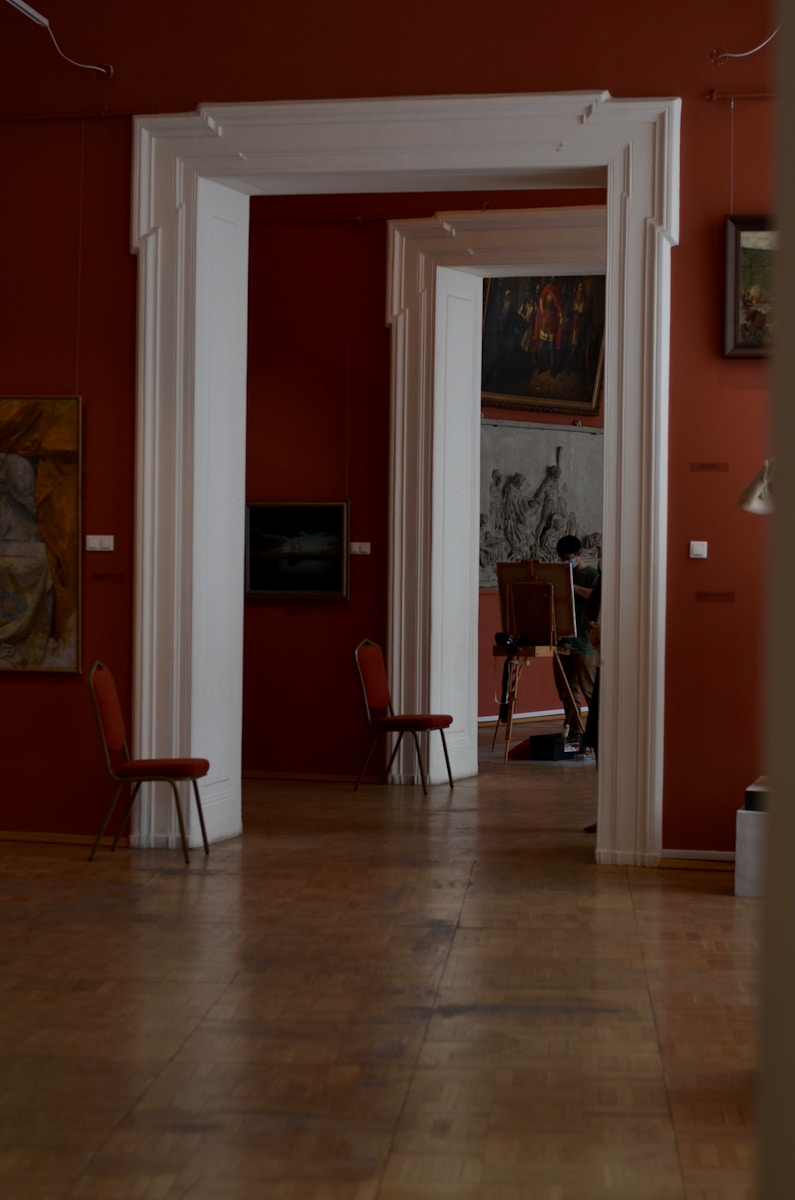 a living room with red walls and white columns
